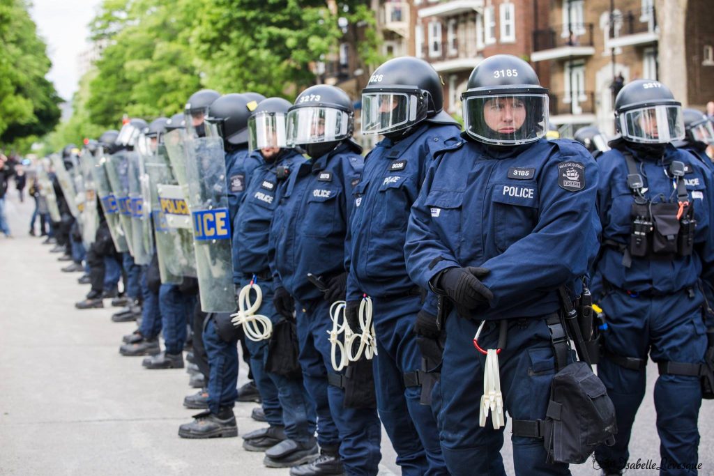 Une ligne de policier de la Ville de Québec portant des menottes en plastique
